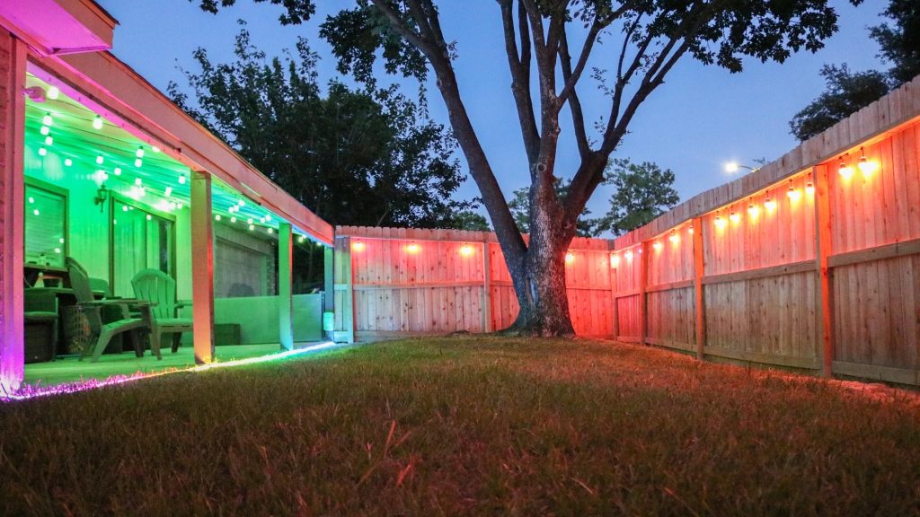 A backyard illuminated with vibrant smart color string lights