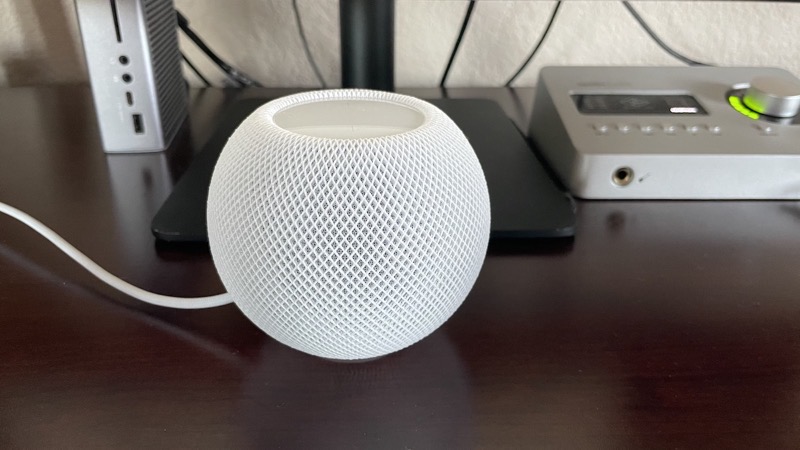 Apple HomePod Mini placed on a modern desk setup, ready to stream Spotify.